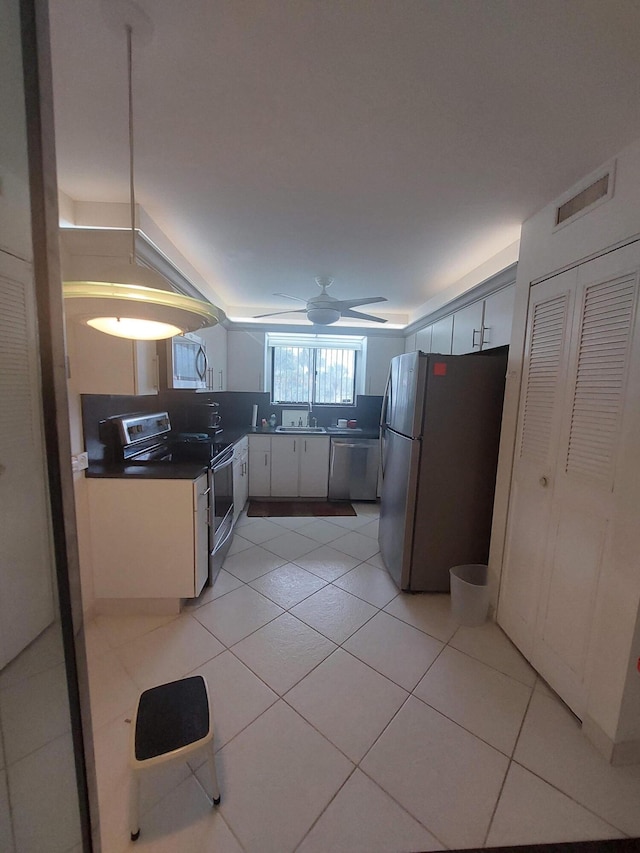 kitchen with ceiling fan, white cabinets, stainless steel appliances, and light tile patterned floors