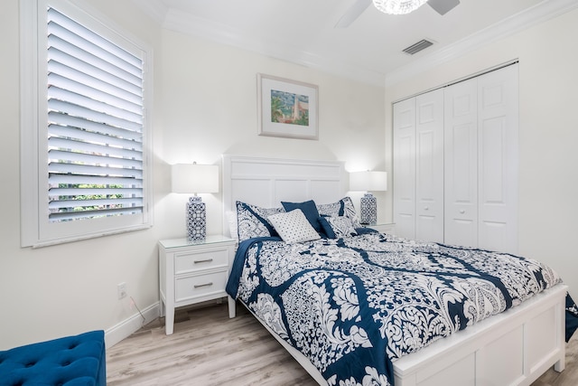 bedroom with ceiling fan, a closet, light hardwood / wood-style floors, and ornamental molding