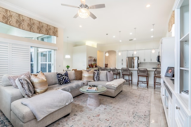 living room with ceiling fan and ornamental molding