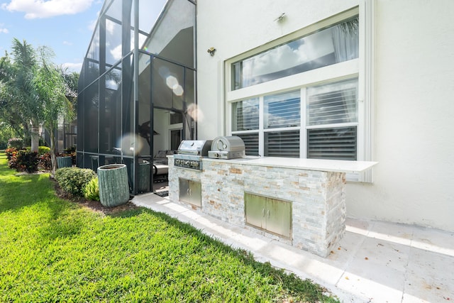 view of patio with glass enclosure and area for grilling