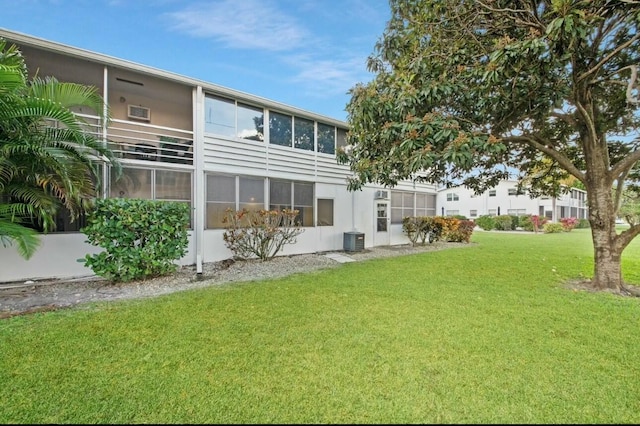 rear view of house with a yard and cooling unit