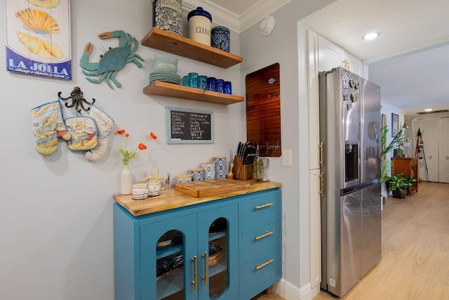 bar with stainless steel fridge with ice dispenser, ornamental molding, blue cabinetry, and light wood-type flooring