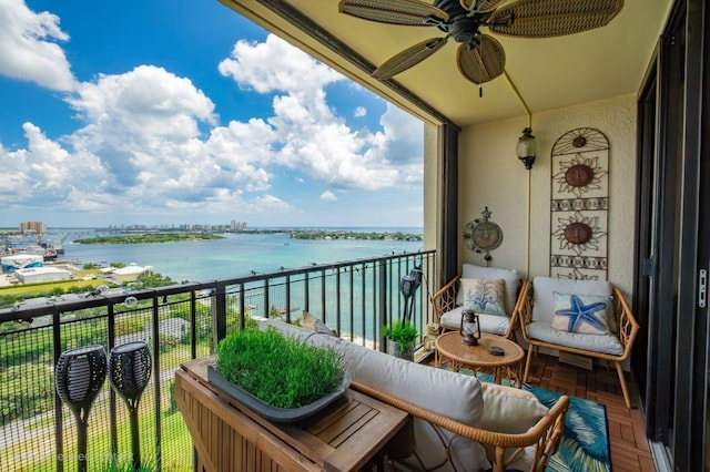 balcony with ceiling fan and a water view