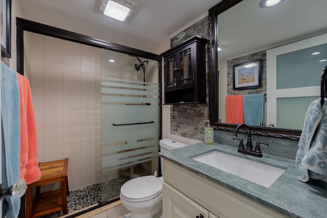 bathroom with toilet, tile walls, walk in shower, and vanity