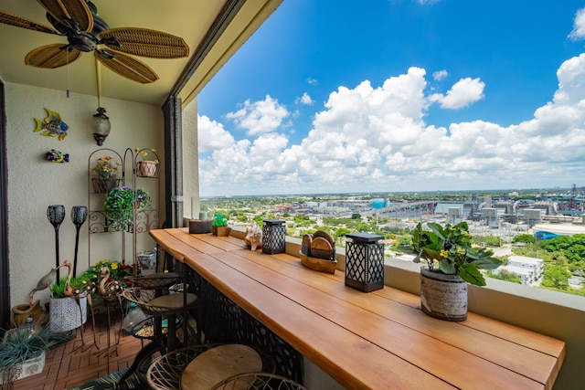 balcony with ceiling fan and a bar