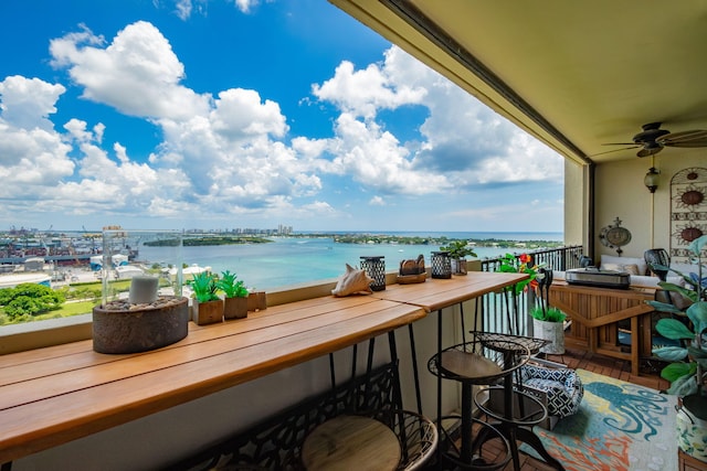 balcony featuring ceiling fan and a water view