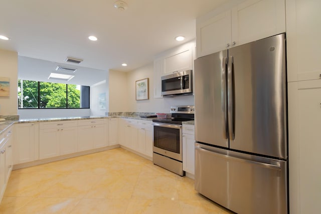 kitchen featuring light stone countertops, white cabinets, and stainless steel appliances