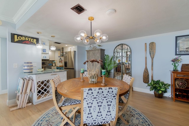 dining area with light wood-type flooring, a chandelier, and crown molding