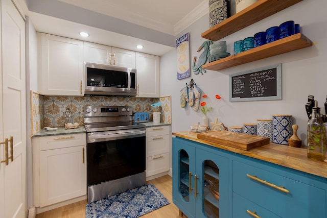 kitchen with wood counters, stainless steel appliances, and white cabinetry