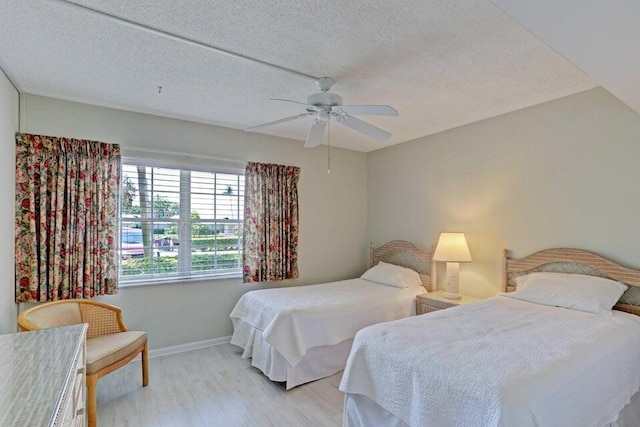 bedroom featuring ceiling fan, a textured ceiling, and light wood-type flooring