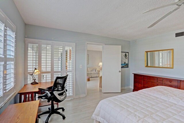 bedroom with multiple windows, ceiling fan, a textured ceiling, and light wood-type flooring