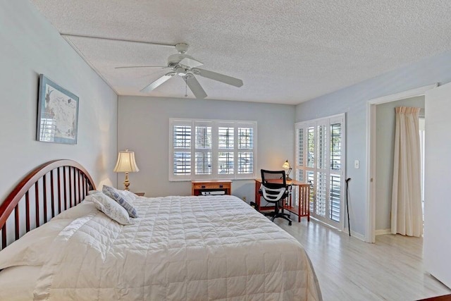 bedroom with a textured ceiling, light hardwood / wood-style floors, and ceiling fan