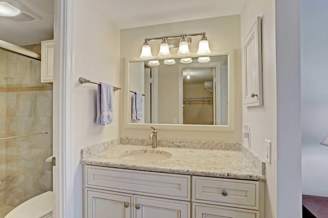 bathroom featuring vanity, an enclosed shower, and toilet