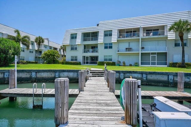 dock area with a lawn and a water view