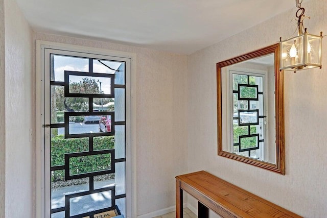 doorway with a wealth of natural light and an inviting chandelier