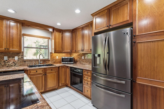 kitchen with decorative backsplash, light stone countertops, sink, and stainless steel appliances