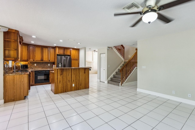 kitchen with stainless steel refrigerator with ice dispenser, tasteful backsplash, a kitchen island, oven, and light tile patterned flooring