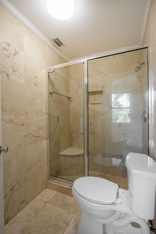 bathroom with tile patterned floors, toilet, a shower with shower door, and crown molding