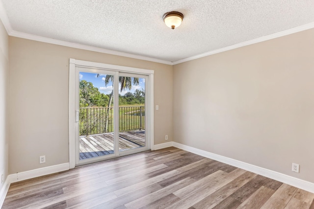 spare room featuring crown molding, light hardwood / wood-style floors, and a textured ceiling