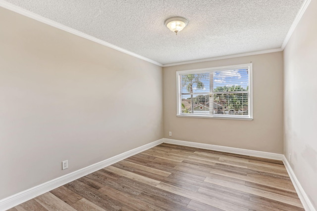 spare room with a textured ceiling, light hardwood / wood-style floors, and crown molding