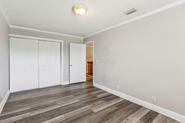 unfurnished bedroom with a textured ceiling, dark hardwood / wood-style floors, and a closet