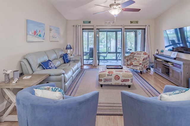 living room featuring ceiling fan, vaulted ceiling, and light wood-type flooring