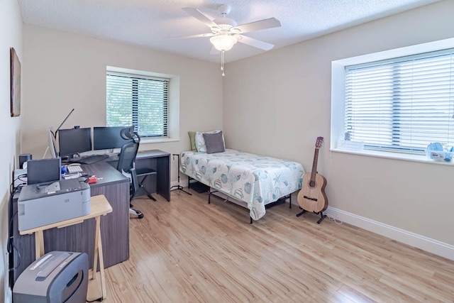 bedroom featuring a textured ceiling, light hardwood / wood-style floors, and ceiling fan