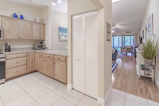 kitchen with a textured ceiling, stainless steel appliances, vaulted ceiling, sink, and light brown cabinets