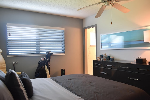 bedroom with ceiling fan and a textured ceiling