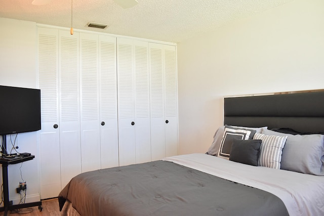 bedroom featuring a closet, wood-type flooring, and a textured ceiling