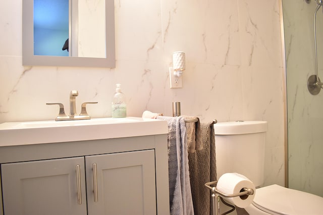 bathroom with walk in shower, vanity, and toilet