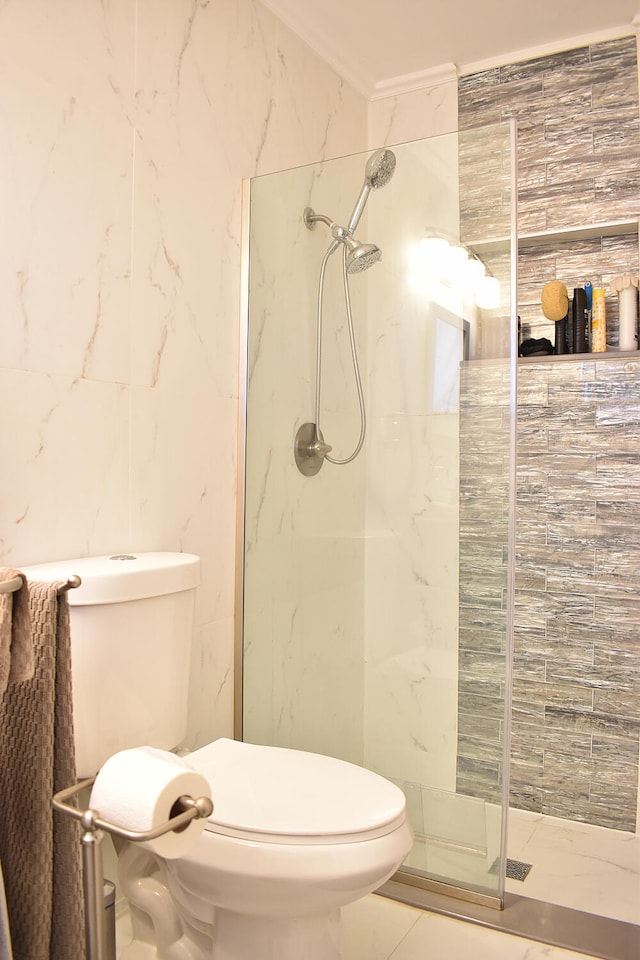 bathroom with toilet, a tile shower, crown molding, and tile walls