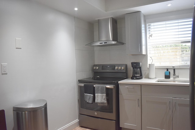 kitchen featuring tasteful backsplash, wall chimney exhaust hood, sink, gray cabinets, and stainless steel electric range oven