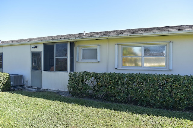 view of side of property with a yard and central air condition unit