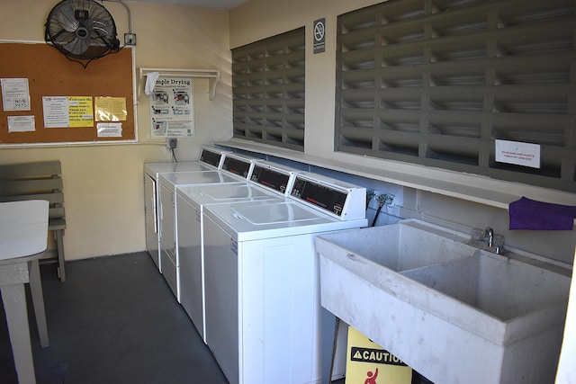 clothes washing area with washing machine and clothes dryer and sink