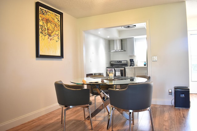 dining room with a wealth of natural light, hardwood / wood-style floors, and a textured ceiling