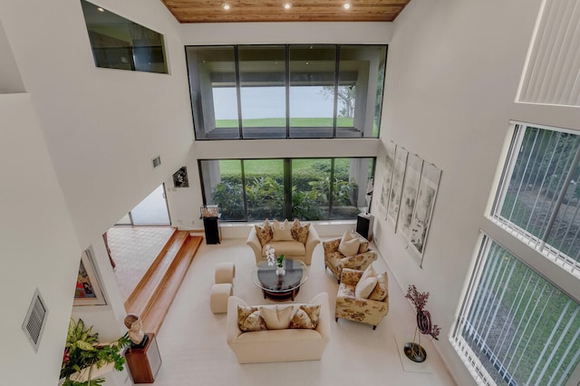 living room featuring wood ceiling and a high ceiling