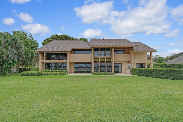 rear view of house featuring a yard