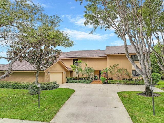 view of front of property featuring a front yard and a garage