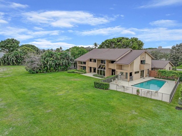 back of property featuring a yard, a fenced in pool, and a patio