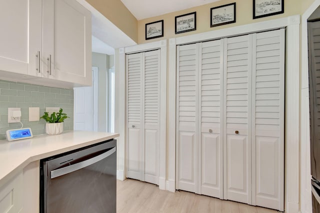 kitchen featuring white cabinetry, dishwasher, light hardwood / wood-style floors, and decorative backsplash