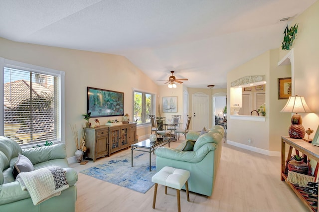 living room featuring lofted ceiling, ceiling fan, and light wood-type flooring