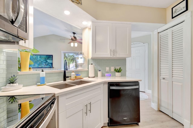 kitchen with sink, tasteful backsplash, appliances with stainless steel finishes, kitchen peninsula, and white cabinets