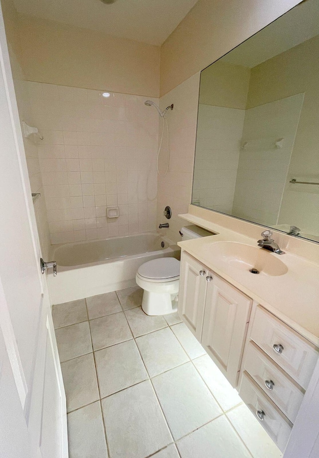 full bathroom featuring tile patterned flooring, vanity, tiled shower / bath combo, and toilet