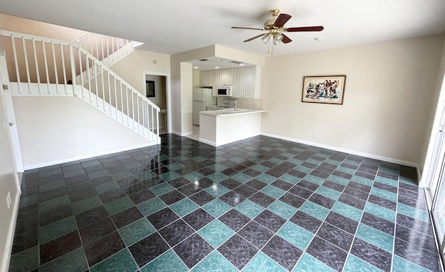 unfurnished living room with ceiling fan