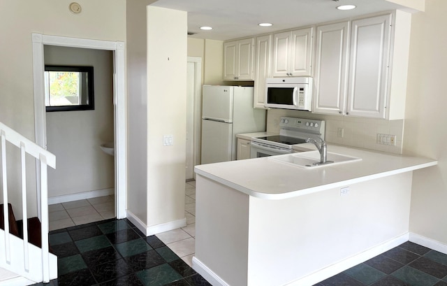 kitchen with white cabinetry, sink, tasteful backsplash, kitchen peninsula, and white appliances