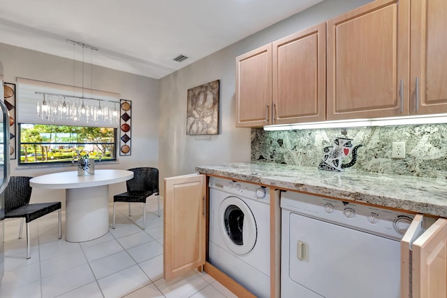 laundry area with washer and dryer, cabinets, and light tile patterned floors