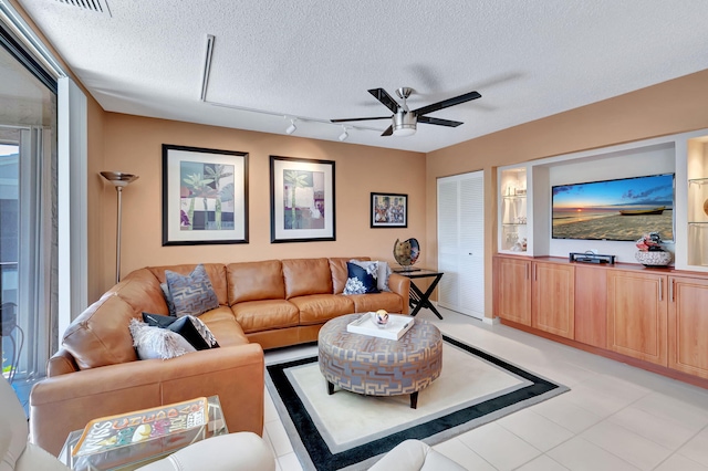 living room with a textured ceiling and ceiling fan