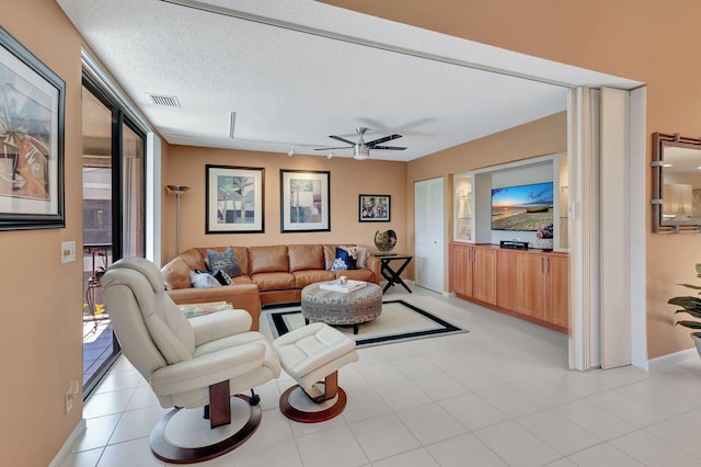 living room featuring a textured ceiling and ceiling fan