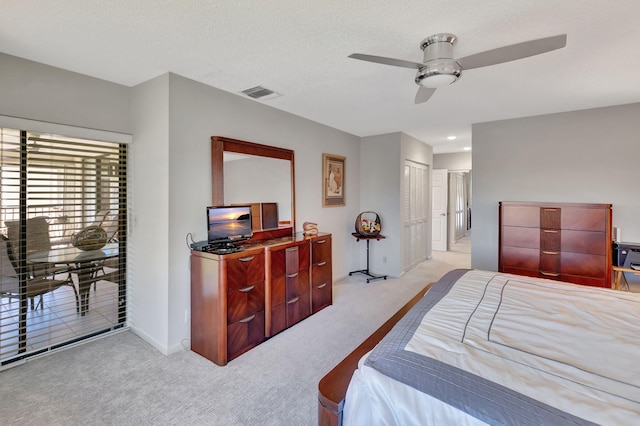 carpeted bedroom featuring a textured ceiling, a closet, and ceiling fan